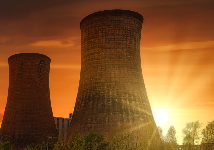 green-grass-field-near-power-plant-during-sunset