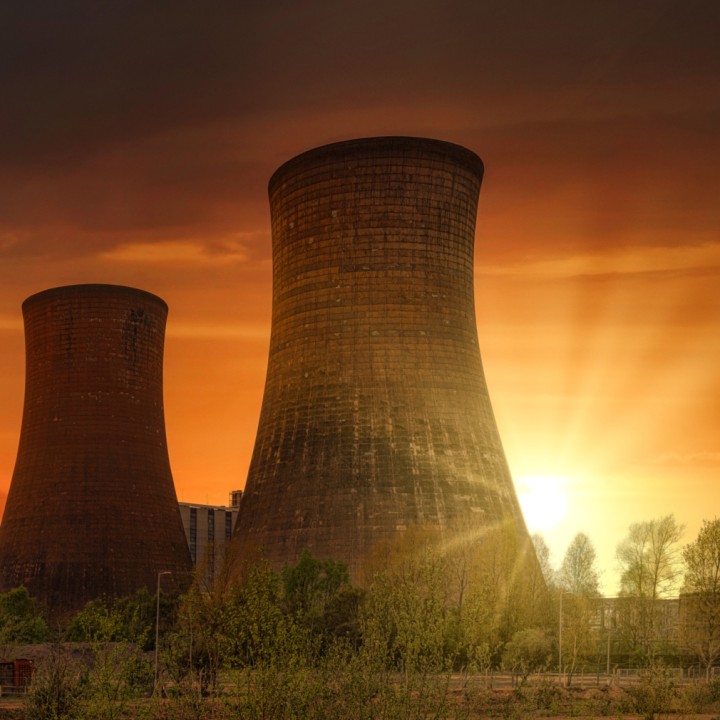 green-grass-field-near-power-plant-during-sunset